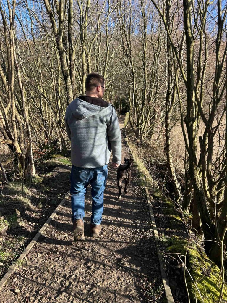 Dog Dad walking Mabel the staffy cross in woodland at Cromwell Bottom in Halifax