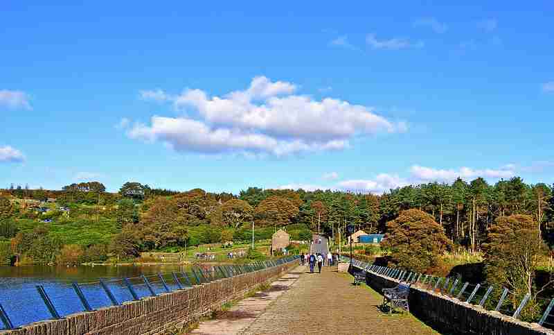 Ogden water reservoir stone walkway with benches and people in the background on a summers day with a blue sky